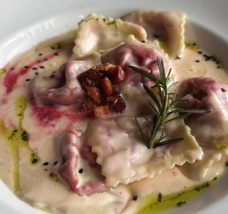 Raviolón de remolacha y provolone con crema y panceta